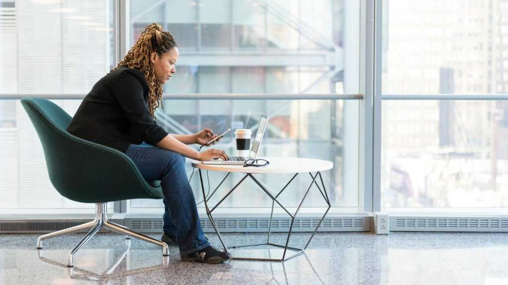 biznesswoman, kobieta pracująca na laptopie przy małym stoliczku. 