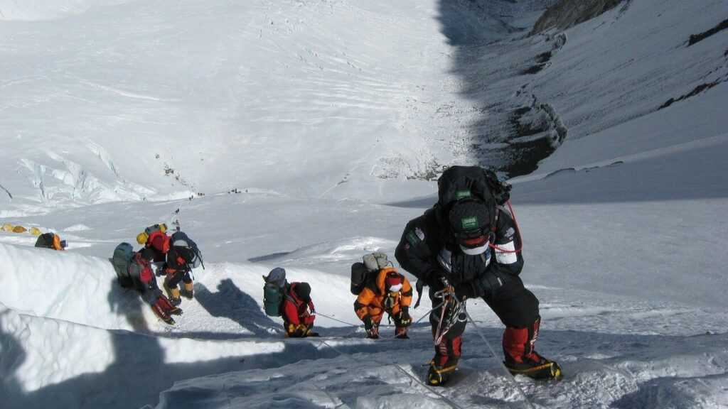 Jak wejść na Mount Everest. Na zdjęciu himalaiści wspinają się po stromej ścianie góry