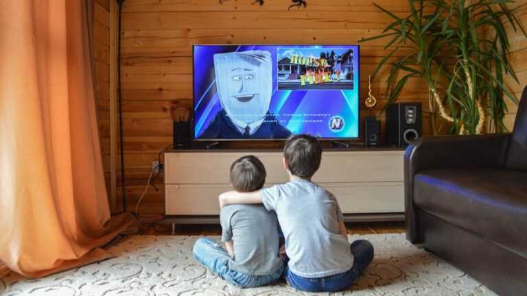 Obraz ojca w kreskówkach. Na zdjęciu dwóch chłopców siedzi przed telewizorem i ogląda bajkę