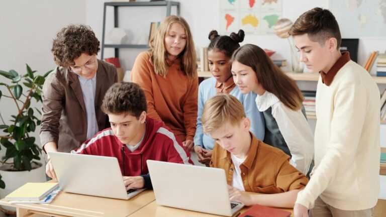 praca indywidualna z uczeniem, nauczycielka z dziećmi w klasie przy laptopie.