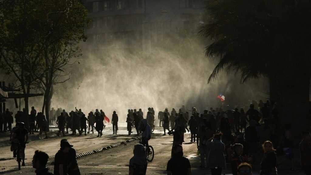 Sytuacja polityczna w Chile. Na zdjęciu ludzie na ulicach miasta w Chile. Być może jest to demonstracja, niektórzy trzymają flagi