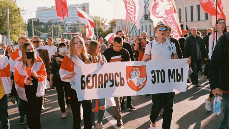 Pragnienie wolności: ludzie w Białorusi w trakcie pochodu z flagami i transparentami