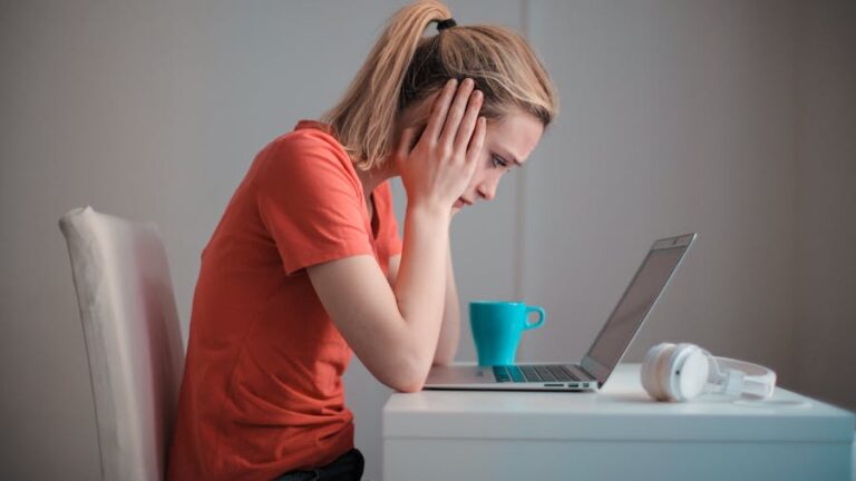 AI w psychoterapii: smutna dziewczyna podpiera głowę rękami i wpatruje się w ekran
