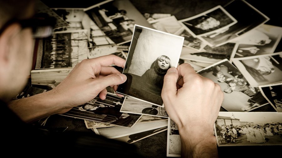 analiza wspomnień, mężczyzna trzyma w ręce stare fotografie