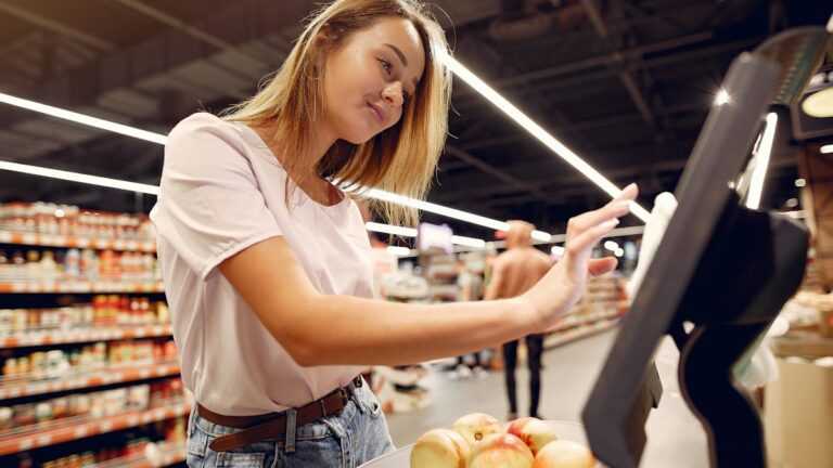Ceny dynamiczne: kobieta waży owoce w supermarkecie