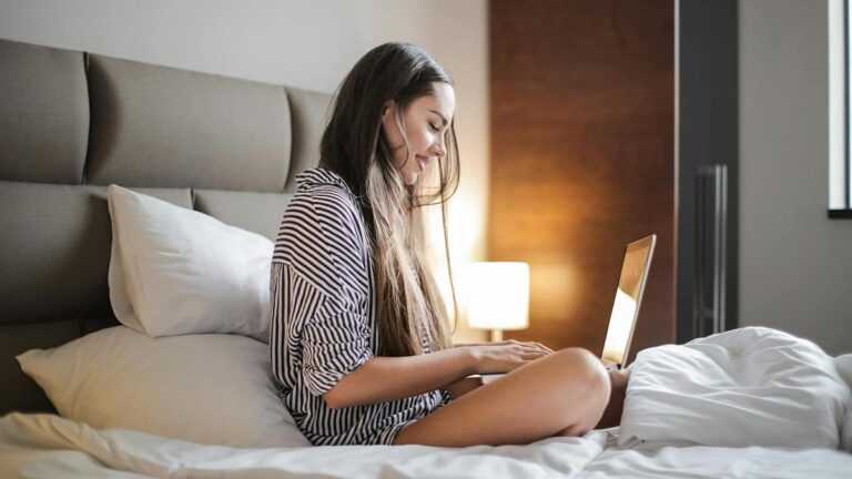 Chiński pokój: kobieta siedzi na łóżku i pisze na laptopie