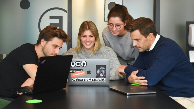 Biznes i social media: grupa pracowników w firmie ogląda coś na laptopie