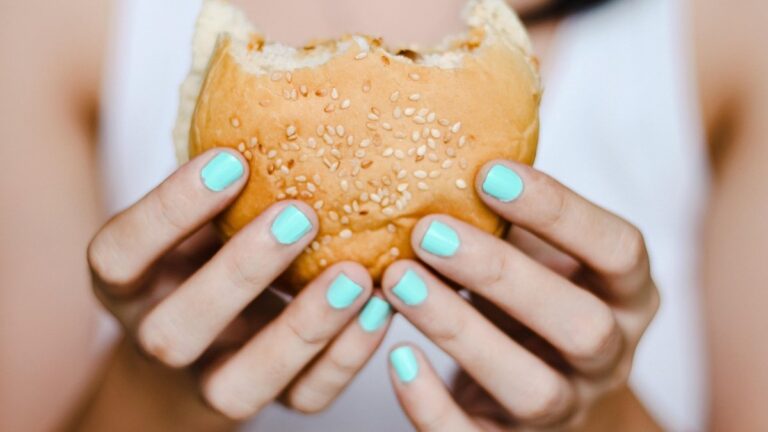 Wpływ diety na mózg, osoba trzyma burgera w dłoniach. Fot. MarieXMartin/pixabay