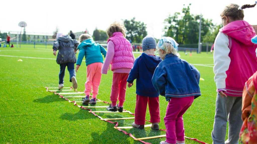 Swobodna zabawa dzieci: grupa dzieci bawi się na boisku szkolnym