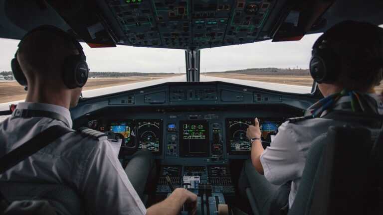 bezemisyjny transport lotniczy, Fot. StockSnap/pixabay. zdjęcie ukazuje dwóch pilotów w kokpicie samolotu tuż przed startem, z widokiem na pas startowy.