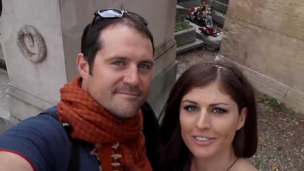 Mroczna turystyka: mężczyzna i kobieta przy grobie Jima Morrisona w Paryżu