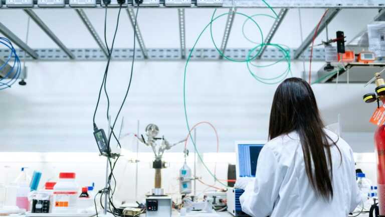 nadprzewodniki w elektronice, Fot. ThisIsEngineering/pexels, naukowiec pracująca przy komputerze w nowoczesnym laboratorium pełnym aparatury badawczej i przewodów.