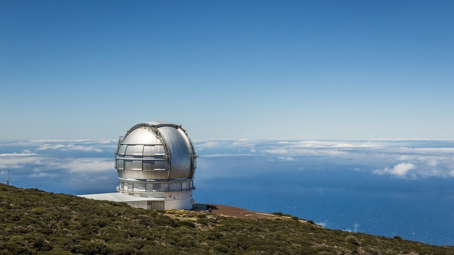 największy teleskop świata, Fot. pixifant/pixabay. Kopuła teleskopu astronomicznego góruje nad chmurami na górskim szczycie z widokiem na ocean.