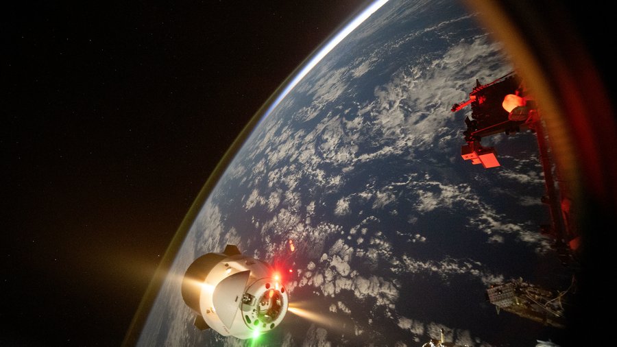 Fot. NASA, Polak w kosmosie, Kapsuła Crew Dragon zbliża się do Międzynarodowej Stacji Kosmicznej na tle Ziemi.