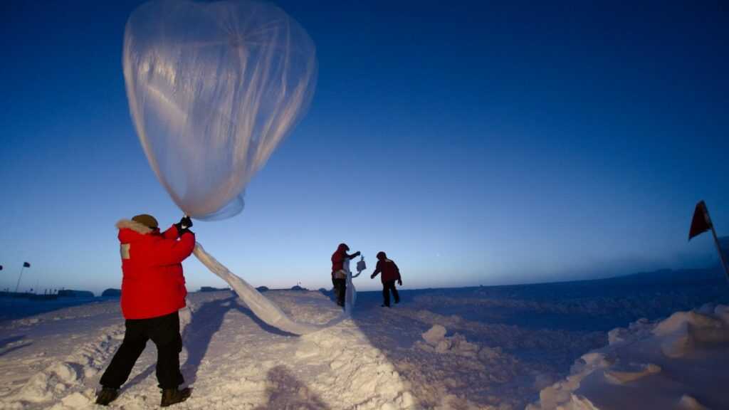 Praca na stacji polarnej: pracownicy stacji polarnej przed wypuszczeniem balonu meteorologicznego