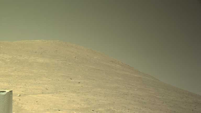 Wulkan na Marsie: Widok z łazika Perseverance na łagodnie wznoszące się marsjańskie wzgórze pod bladym niebem. Fot. NASA / JPL-Caltech.