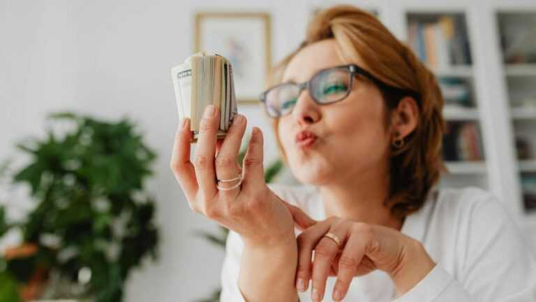 Emocjonalne podejmowanie decyzji: kobieta patrzy na plik banknotów