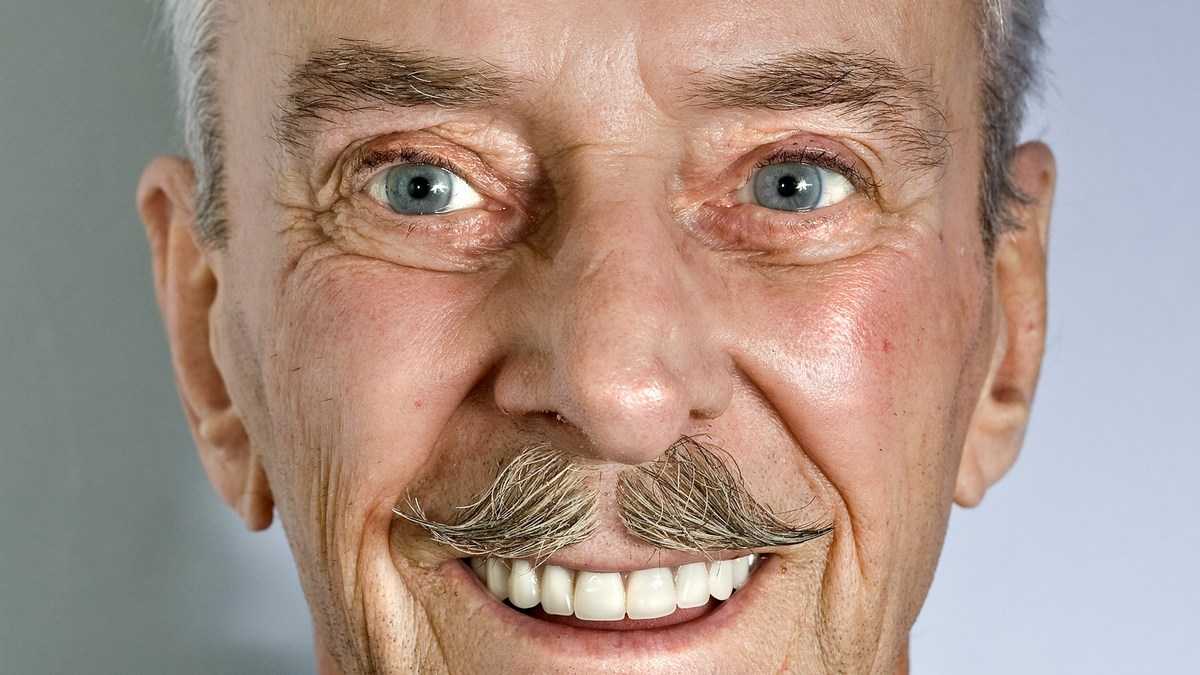 Obietnice wyborcze a rzeczywistość: uśmiechnięty mężczyzna z wąsikiem