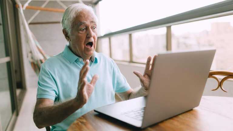 Rage bait: szkokowany mężczyzna patrzy na ekran laptopa