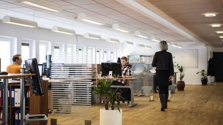 AI w firmie: Nowoczesne biuro typu open space z pracownikami przy komputerach.