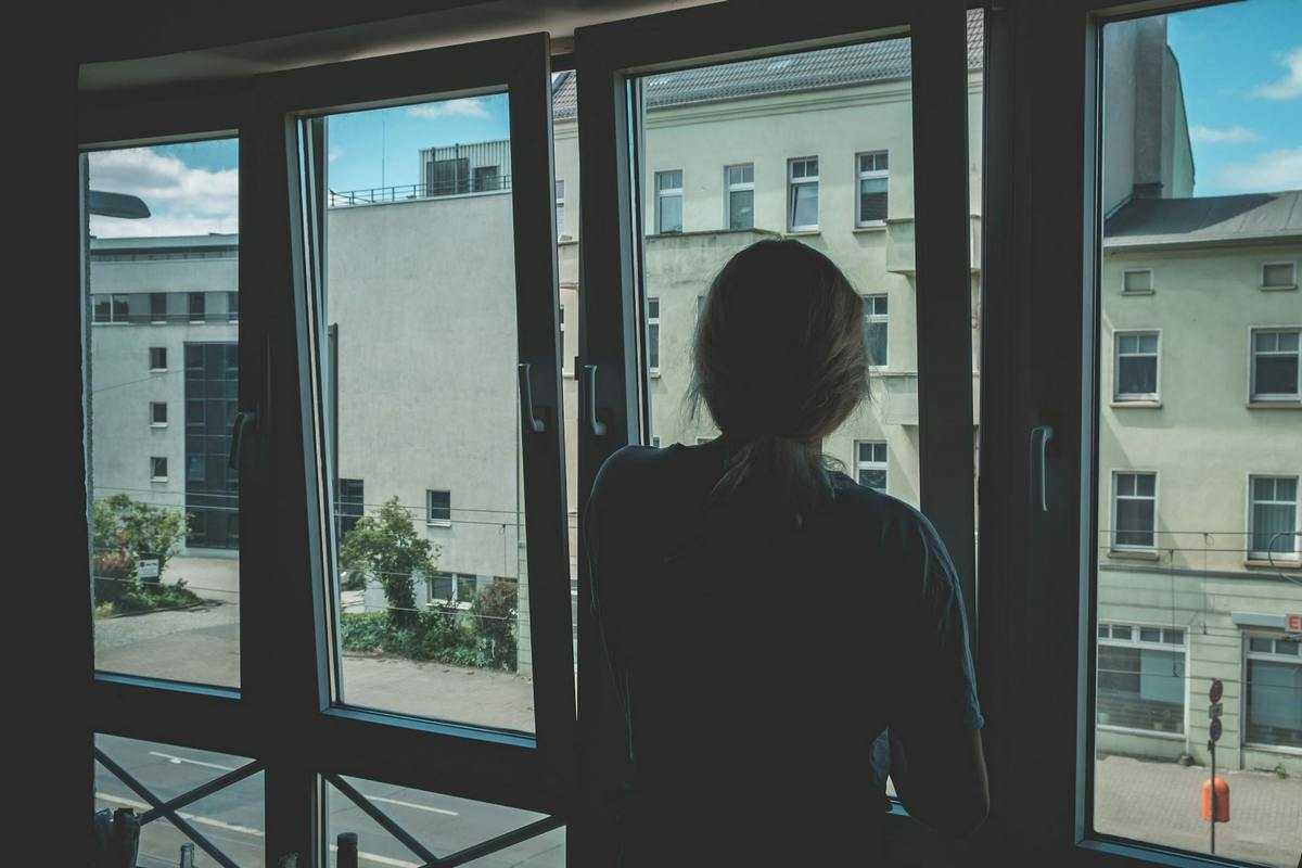 Pamięć u kobiet: kobieta wygląda przez okno w miejskim otoczeniu