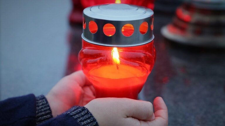 Zapalony znicz. Symboliczny obraz pamięci o bliskich w Polsce, tuż przed Dniem Wszystkich Świętych, kiedy tysiące rodzin odwiedza cmentarze mimo rosnących kosztów pochówku i utrzymania grobów.