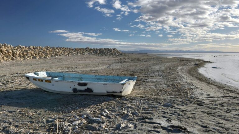 Toksyczny pył: widok na wyschnięty fragment jeziora Salton Sea, na wyschniętym dnia porzucona łódka. Fot. Greg Bulla / Unsplash