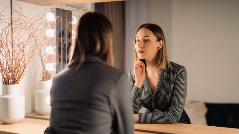 Wygląd w pracy: pewna siebie, elegancko ubrana kobieta, przegląda się w lustrze. Fot ArthurHidden / freepik