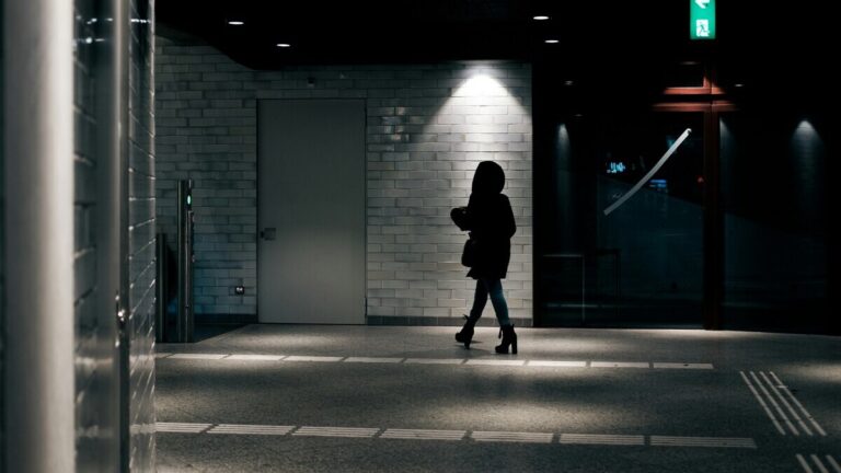 Kobieta idąca samotnie w ciemnym przejściu, symbolizująca prostytucję w Polsce i konsekwencje prostytucji dla kobiet także w erze Only Fans.
