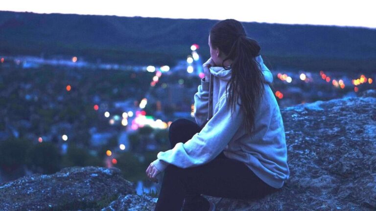 młoda osoba samotna w mieście nocą – ilustracja wpływu samotności na zdrowie i proces przyspieszonego starzenia