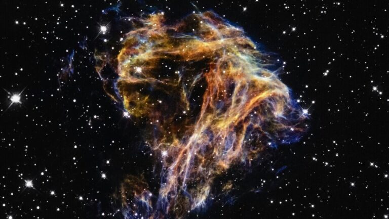 Najstarsza supernowa w kosmosie – kolorowa pozostałość po eksplozji gwiazdy z jasnymi włóknami gazu i pyłu na tle czarnej przestrzeni pełnej gwiazd.