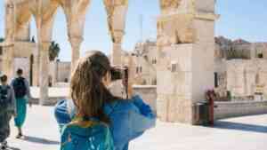 Młoda turystka z plecakiem robi zdjęcie zabytkowej architektury podczas miejskiego wyjazdu