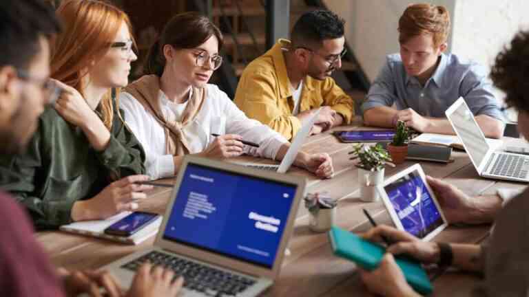 Młodzi pracownicy podczas wspólnej pracy przy laptopach – pokolenie Z praca w nowoczesnym biurze