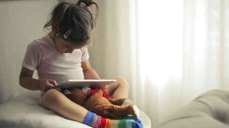 Dziecko trzyma na kolanach tablet.