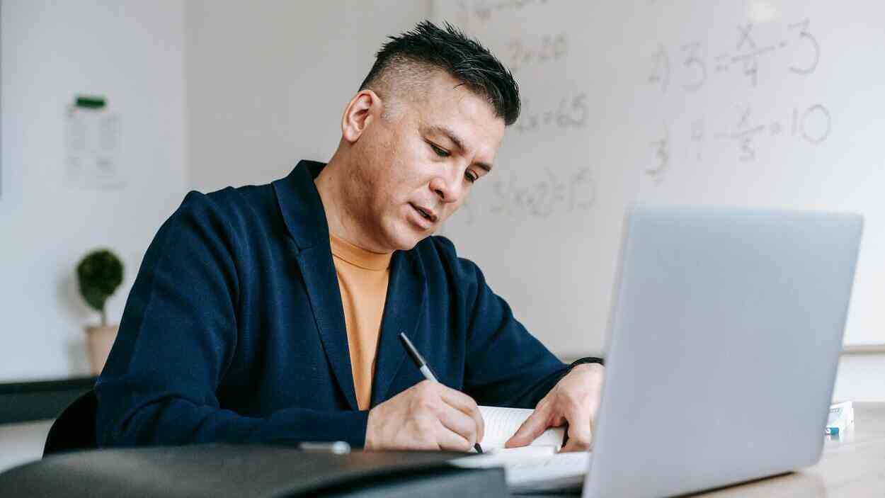 Nauczyciel pracujący z laptopem w klasie – sztuczna inteligencja w szkole