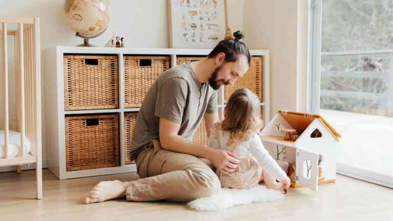 Mężczyzna bawi się z dzieckiem na podłodze