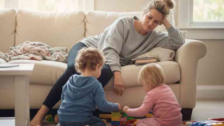 matka smutna siedzi na kanapie, obok bawią się dzieci