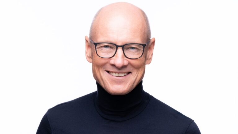 Portret dr Tadeusza Oleszczuka, eksperta w dziedzinie zdrowia jelit i hormonów kobiet, uśmiechniętego na jasnym tle.