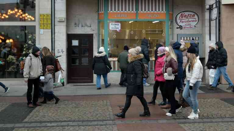 ludzie idą tłumnie ulicą mijając wystawę sklepową