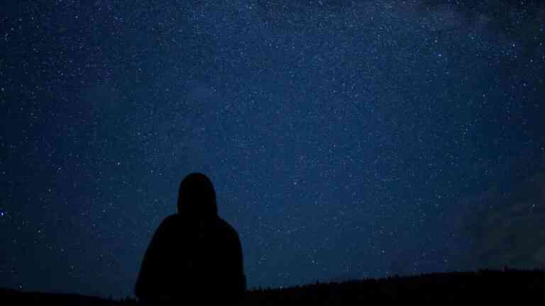 Sylwetka człowieka na tle nocnego nieba pełnego gwiazd — refleksja nad naturą czasu i jego percepcją