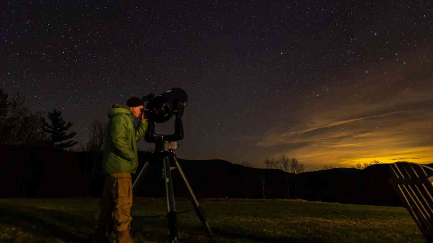 Nowa teoria grawitacji wyjaśni największą zagadkę kosmologii? Na zdjęciu: mężczyzna obserwujący gwiazdy przez teleskop