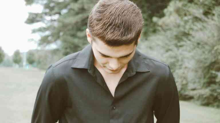 chłopak w czarnej koszuli ze spuszczoną głową