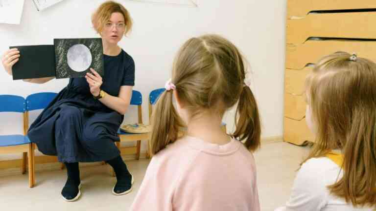 Kobieta tłumaczy coś dwóm dziewczynkom