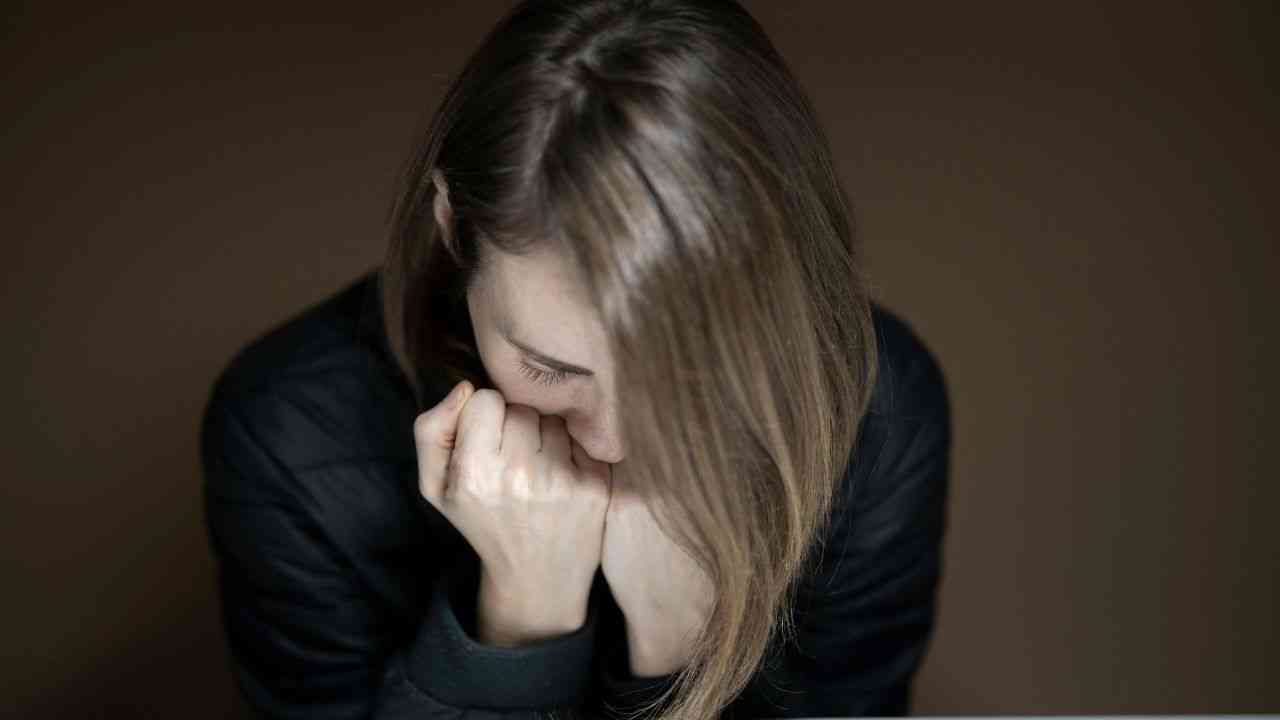 Nowe terapie depresji bez leków? Organiczne białko może zastąpić farmaceutyki. Na zdjęciu: kobieta w czarnej bluzce pochyla się