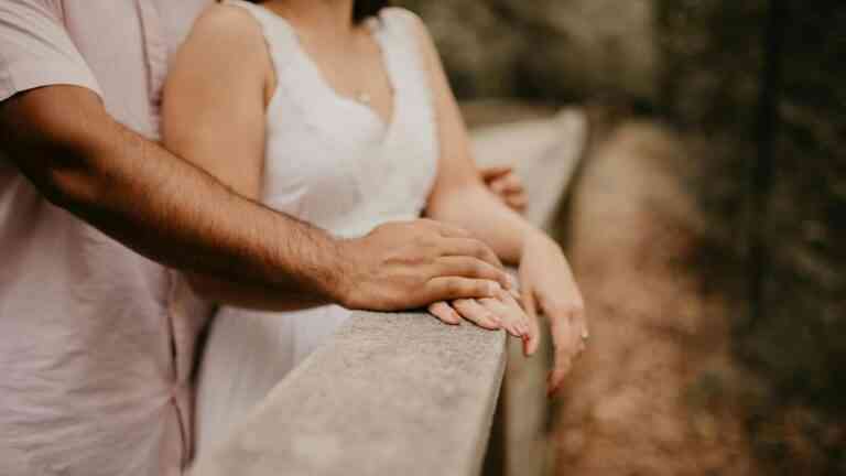 Para trzymająca się za ręce na moście, symbol bliskości i relacji.