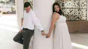 Miłość po latach. Kobieta i mężczyzna trzymają się za palce, opierając się o słup