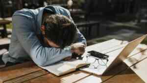 Lęk przed podejmowaniem decyzji blokuje inwestowanie. Na zdjęciu: mężczyzna pochyla się nad stołem przed komputerem