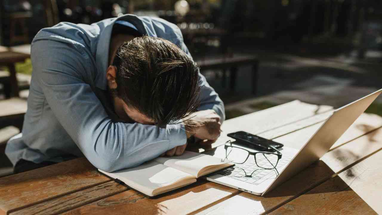 Lęk przed podejmowaniem decyzji blokuje inwestowanie. Na zdjęciu: mężczyzna pochyla się nad stołem przed komputerem