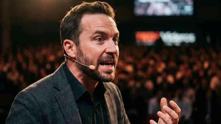 Charyzmatyczny mężczyzna z mikrofonem przemawiający z pasją na konferencji, pokazujący, jak mówić płynnie i angażować publiczność.