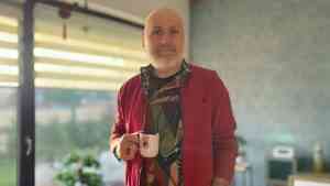 Jarosław Gibas trzyma kubek w dłoni podczas rozmowy o manipulacji emocjami społecznymi i wpływie lęku na decyzje